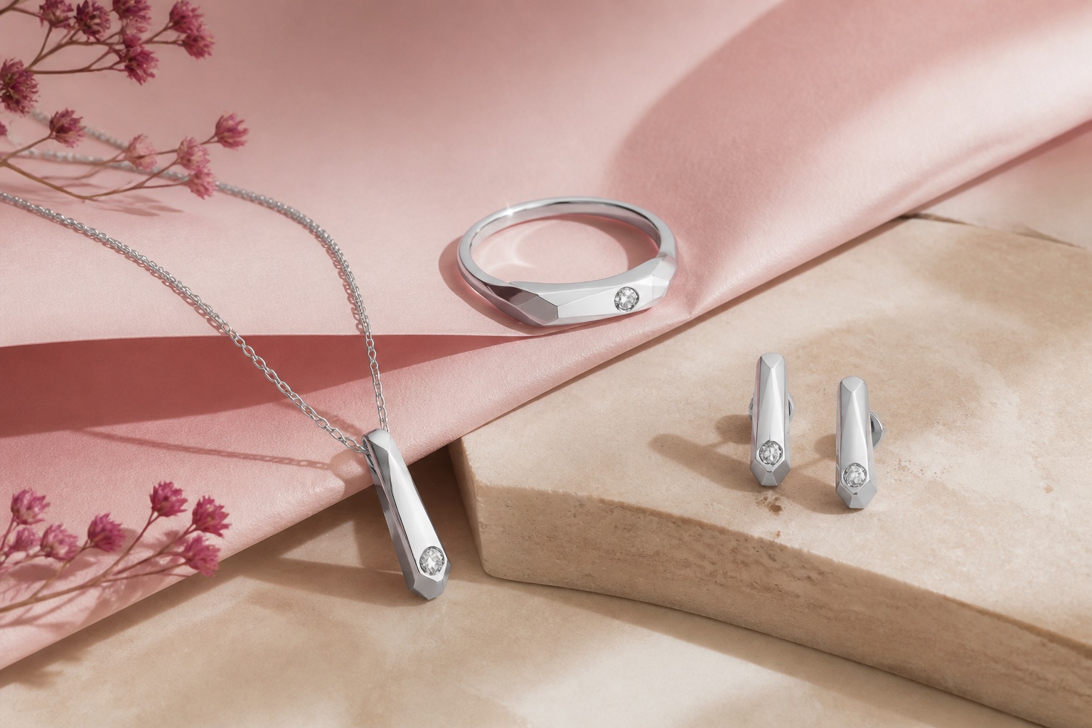 Sculptural silver jewellery arranged as a still life