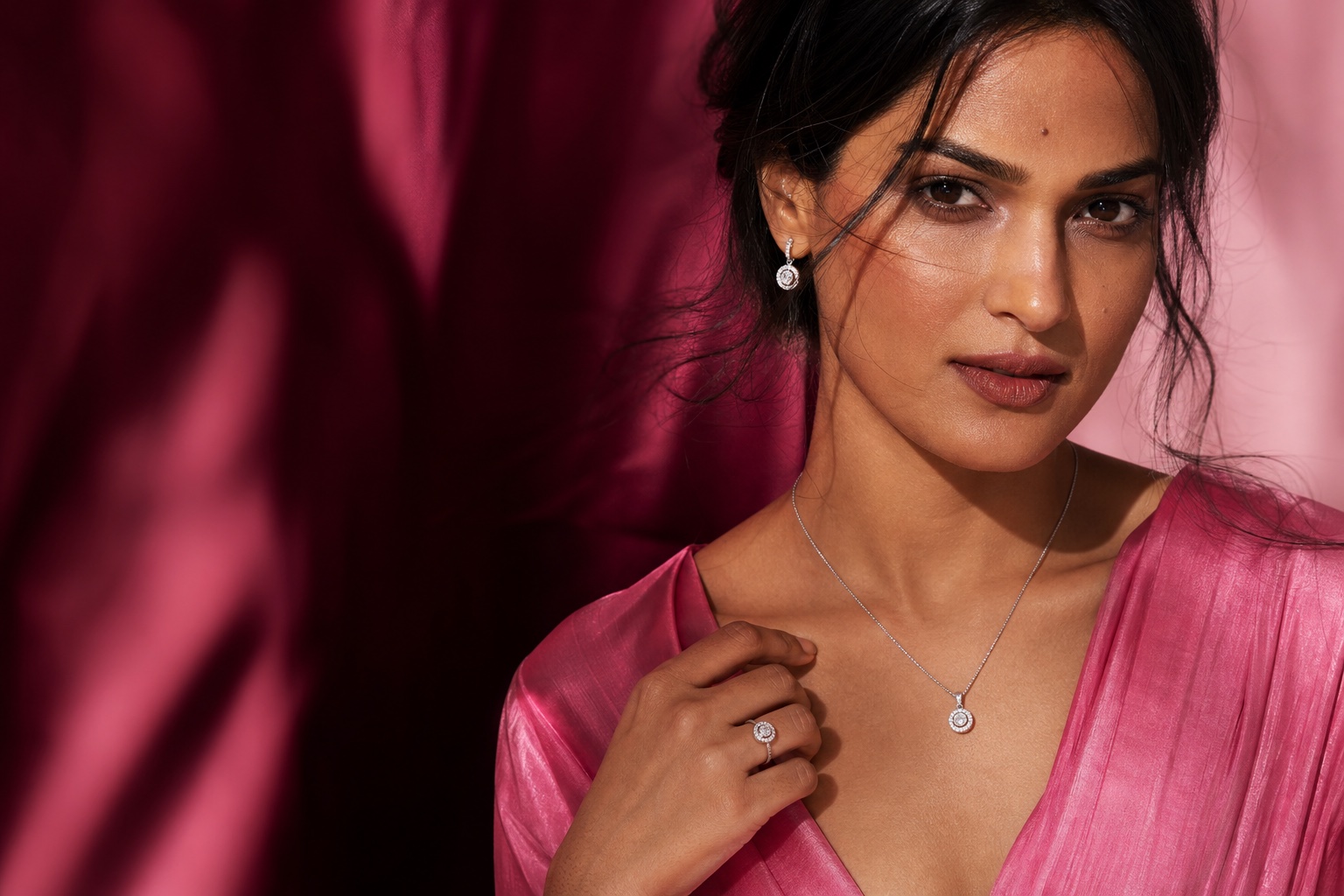 A woman in rose silk wearing delicate silver jewellery