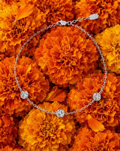 The Classic Station Bracelet resting on marigold flowers