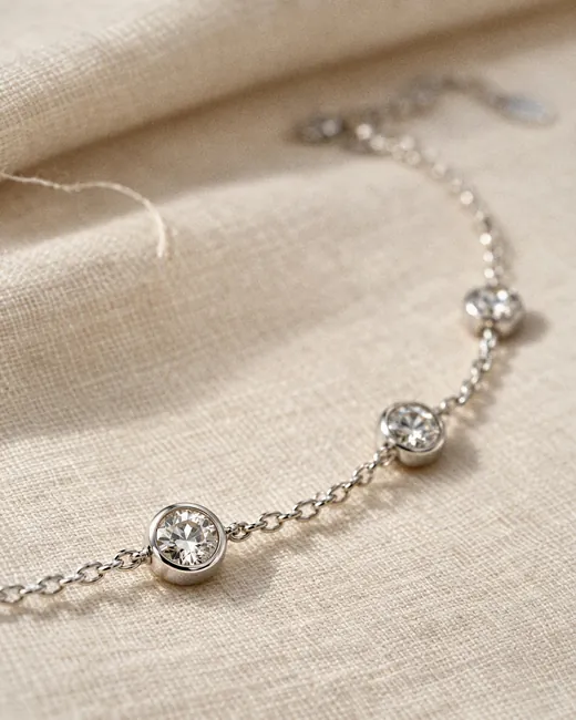 The Classic Station Bracelet laid on cream silk