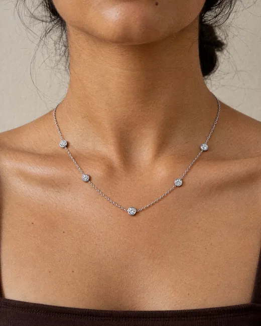 The Classic Station Necklace lying along a woman’s collarbone