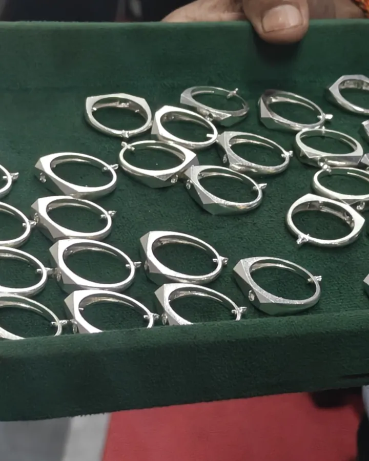 Cast silver ring blanks laid out on a green tray